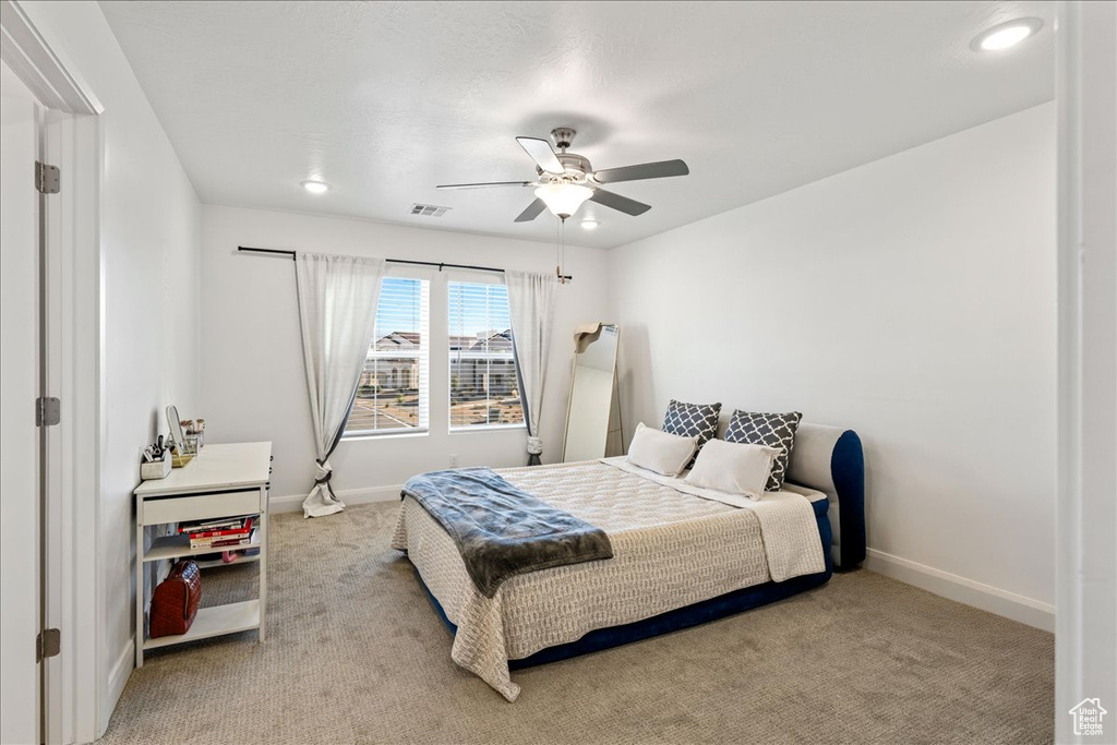 Bedroom with light colored carpet, ceiling fan, and recessed lighting
