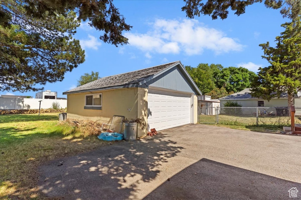 View of side of property with a detached garage and an outdoor structure