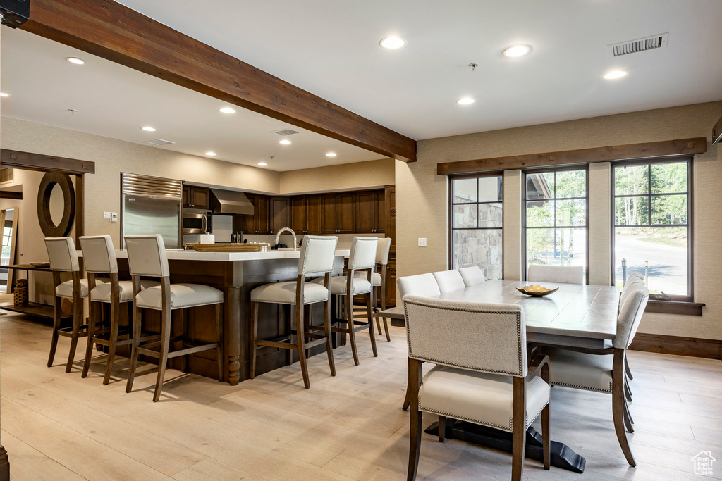 Dining room featuring beamed ceiling, recessed lighting, and light wood-style floors