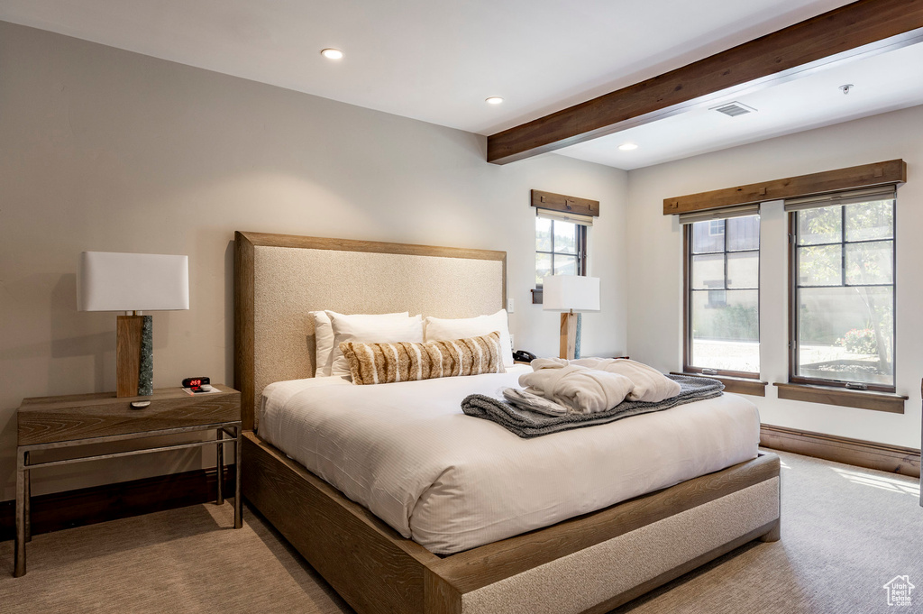 Carpeted bedroom with beam ceiling and recessed lighting