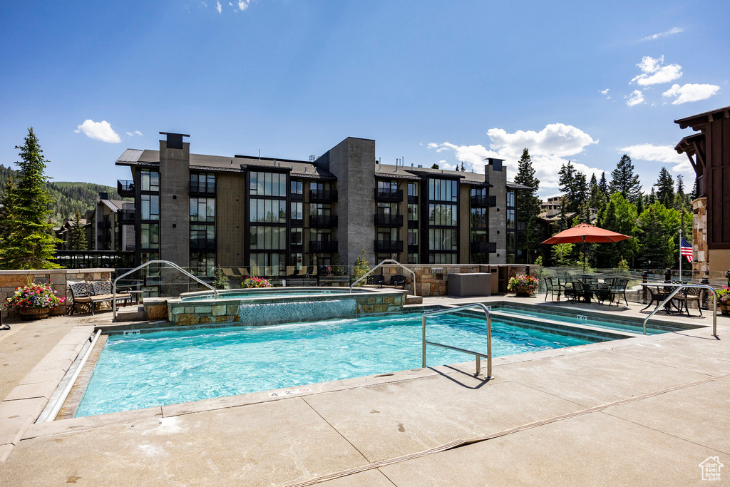 View of pool featuring a patio area and a pool with connected hot tub