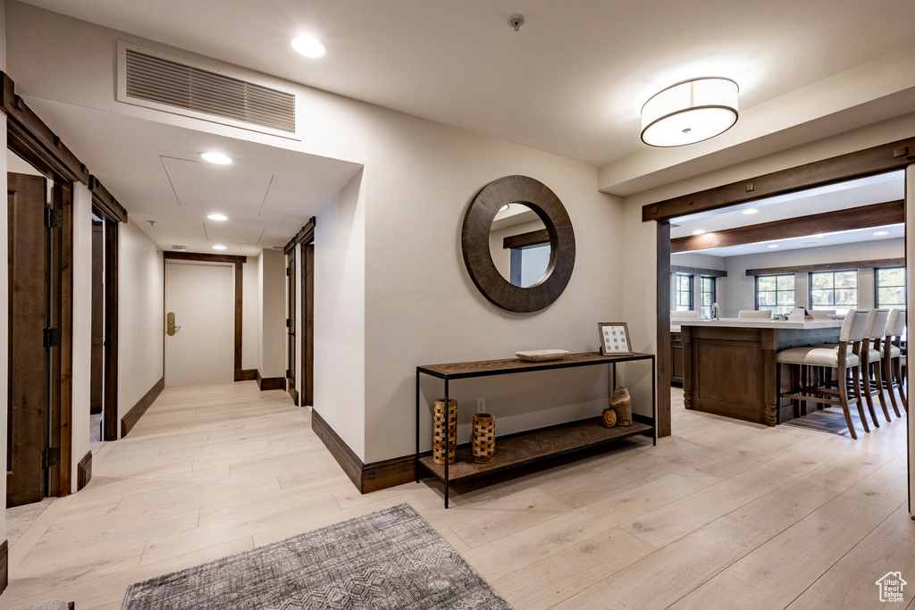 Corridor with light wood-style floors and recessed lighting