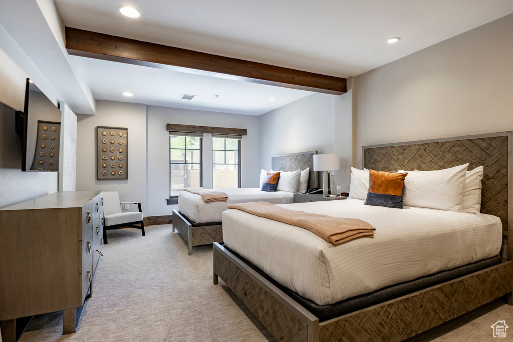 Bedroom with beam ceiling, light carpet, and recessed lighting