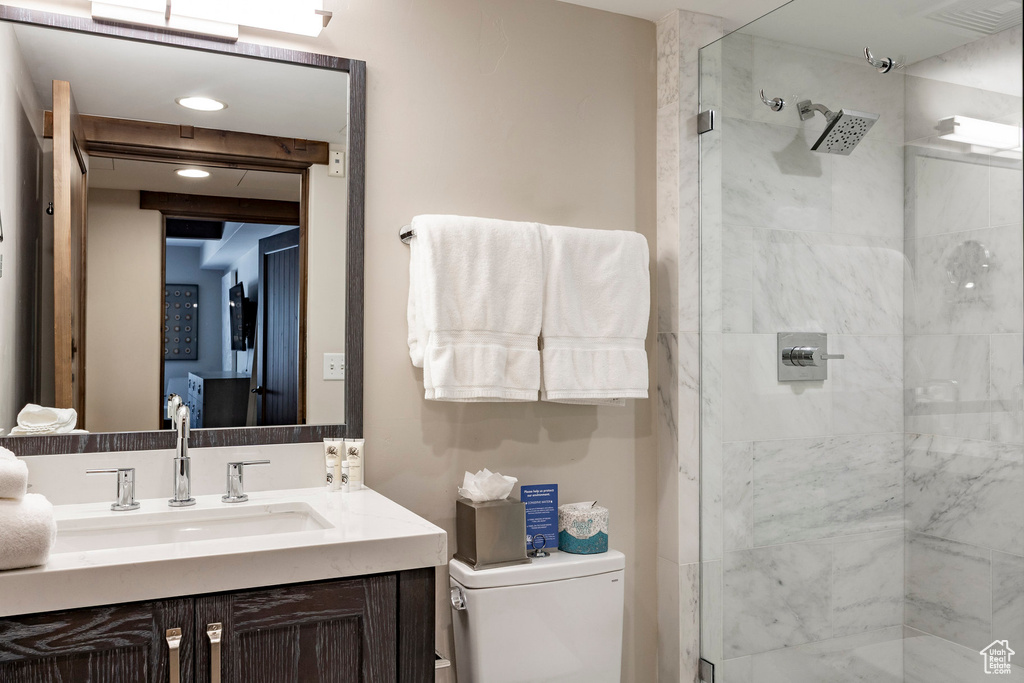 Full bath featuring a stall shower and vanity