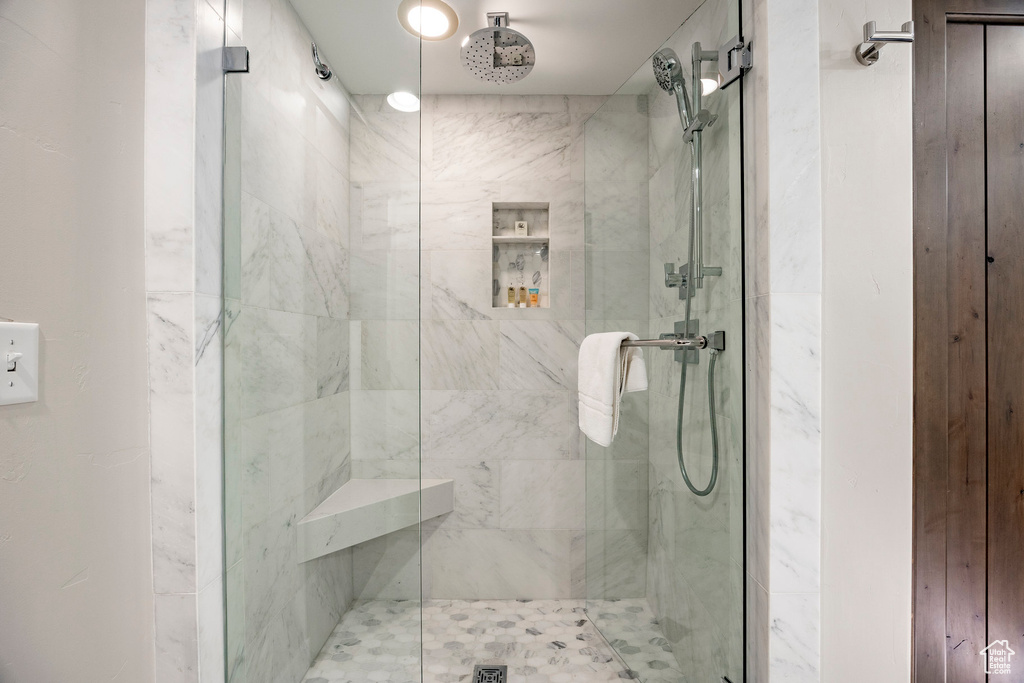 Full bathroom with a marble finish shower