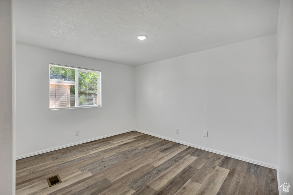 Unfurnished room with wood finished floors and baseboards