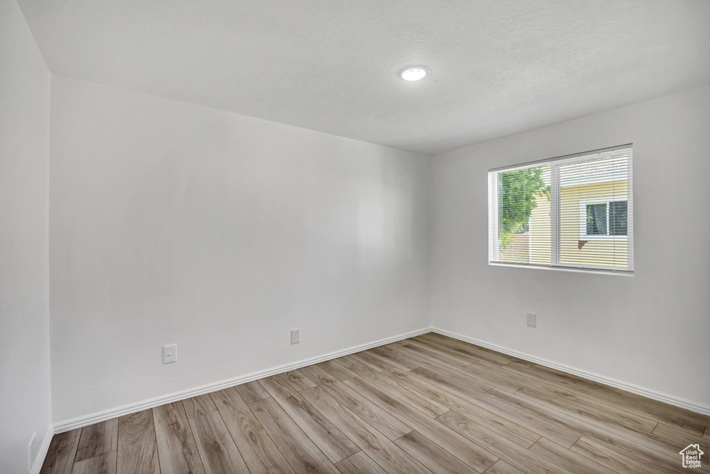 Empty room featuring wood finished floors and baseboards