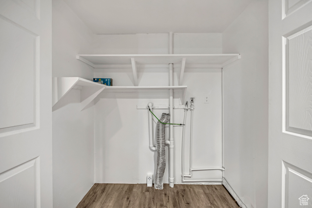 Walk in closet with wood finished floors
