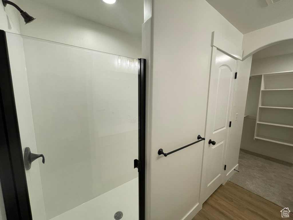 Bathroom featuring a shower stall and wood finished floors