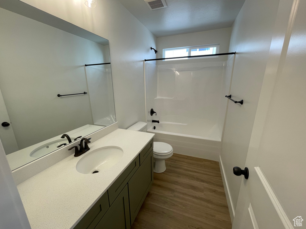 Full bathroom with vanity, wood finished floors, and bathtub / shower combination