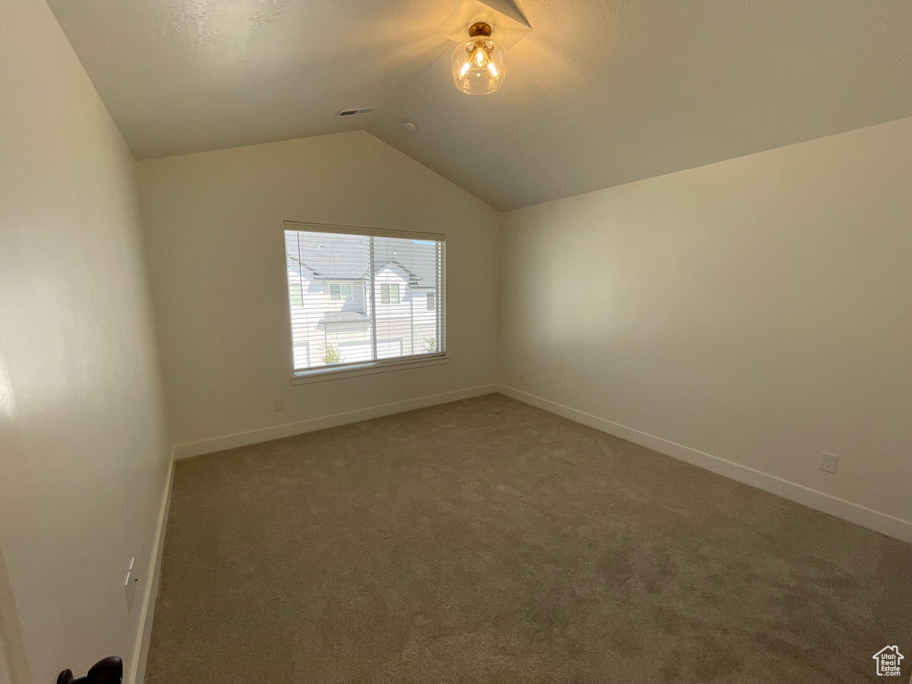 Additional living space featuring vaulted ceiling and carpet