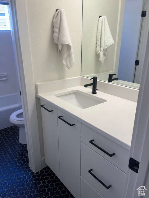 Full bath with vanity and tile patterned flooring