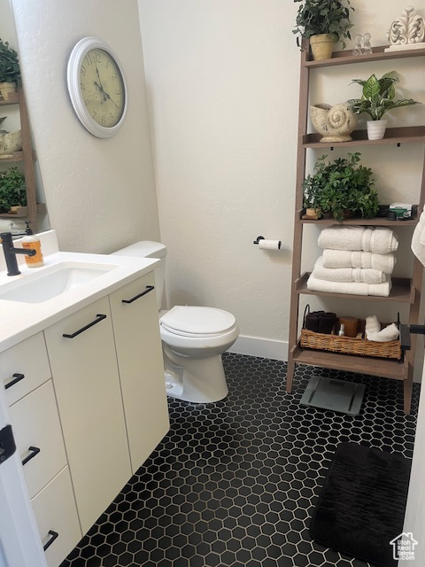 Half bathroom featuring vanity and tile patterned flooring