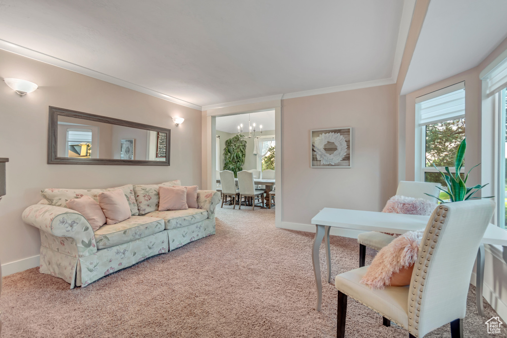 Living room featuring a chandelier, carpet, crown molding, and healthy amount of natural light