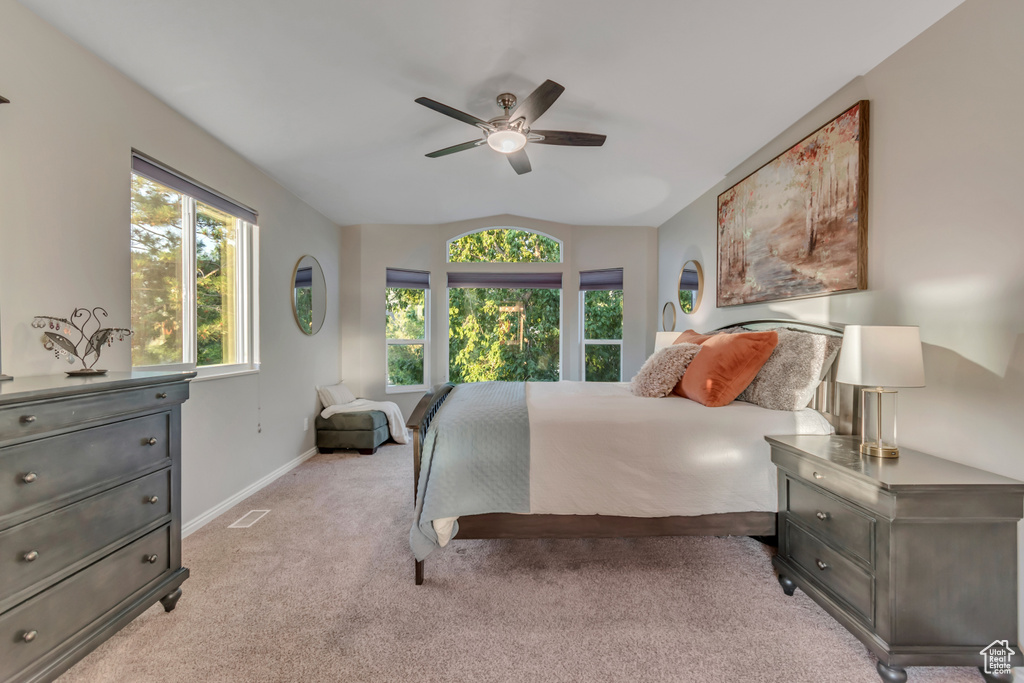 Bedroom featuring light colored carpet, vaulted ceiling, and ceiling fan