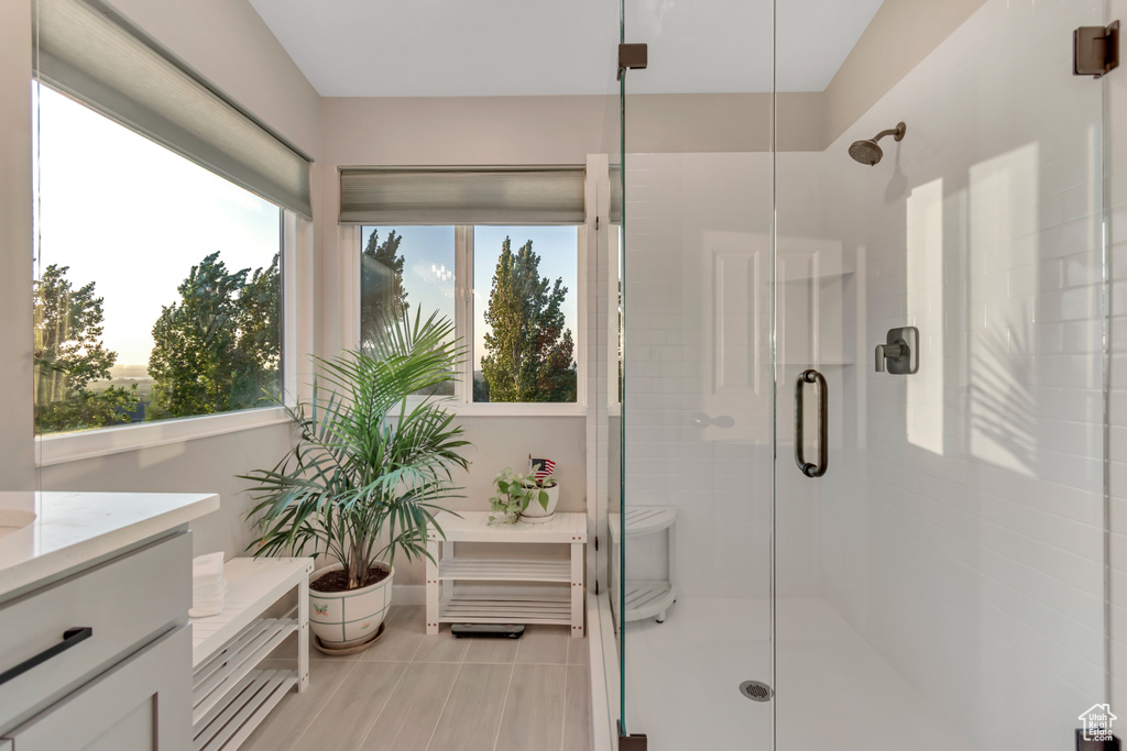 Full bath featuring vanity, a stall shower, and plenty of natural light