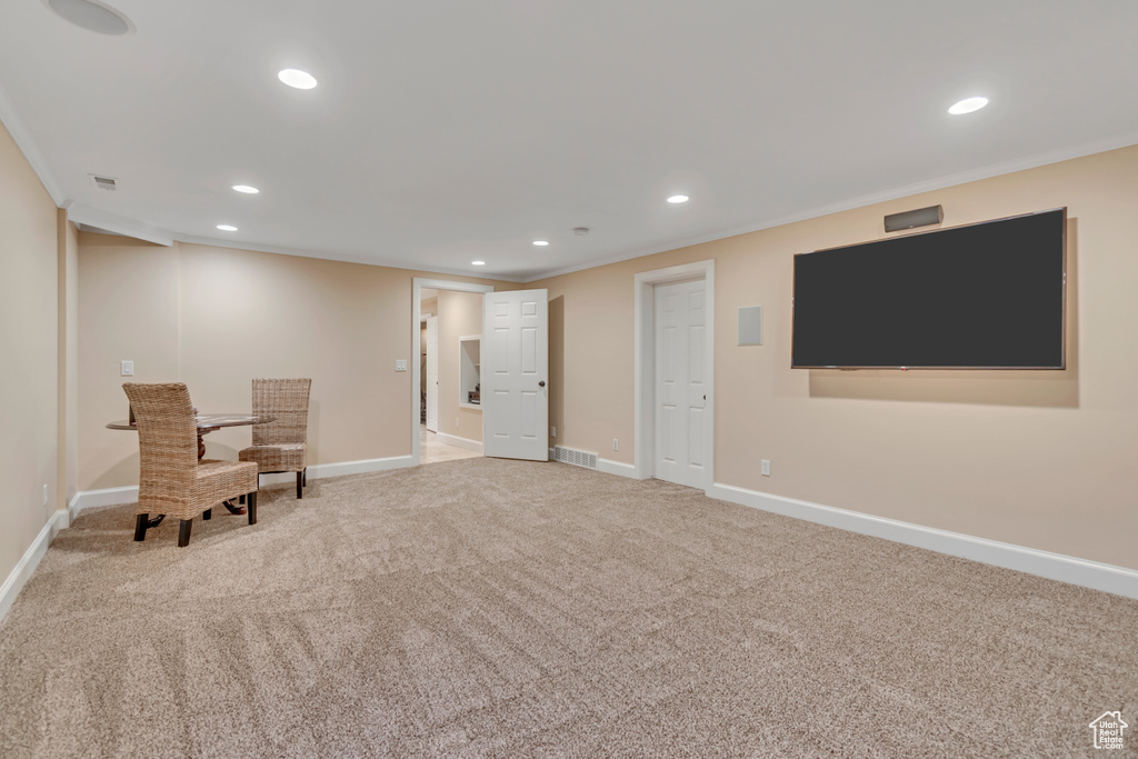 Living area with crown molding, recessed lighting, and carpet