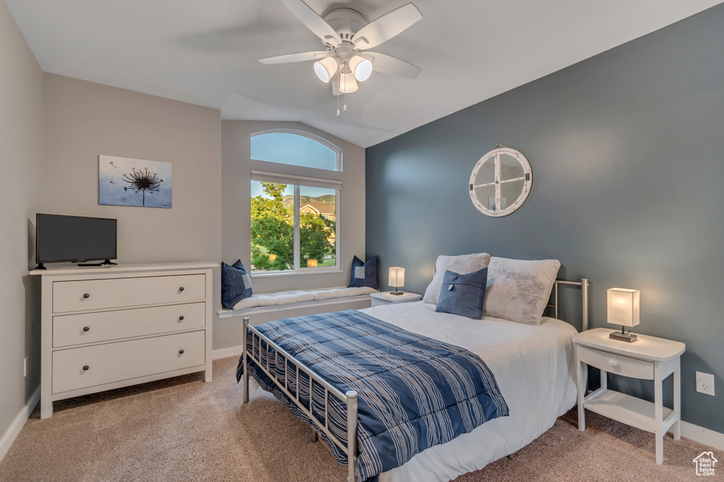 Bedroom featuring lofted ceiling, light colored carpet, and a ceiling fan