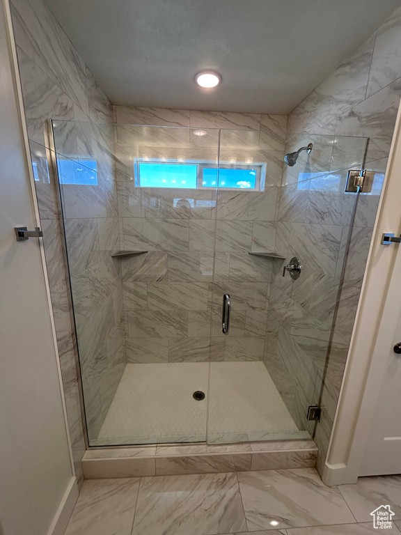 Bathroom with a shower stall and marble finish flooring