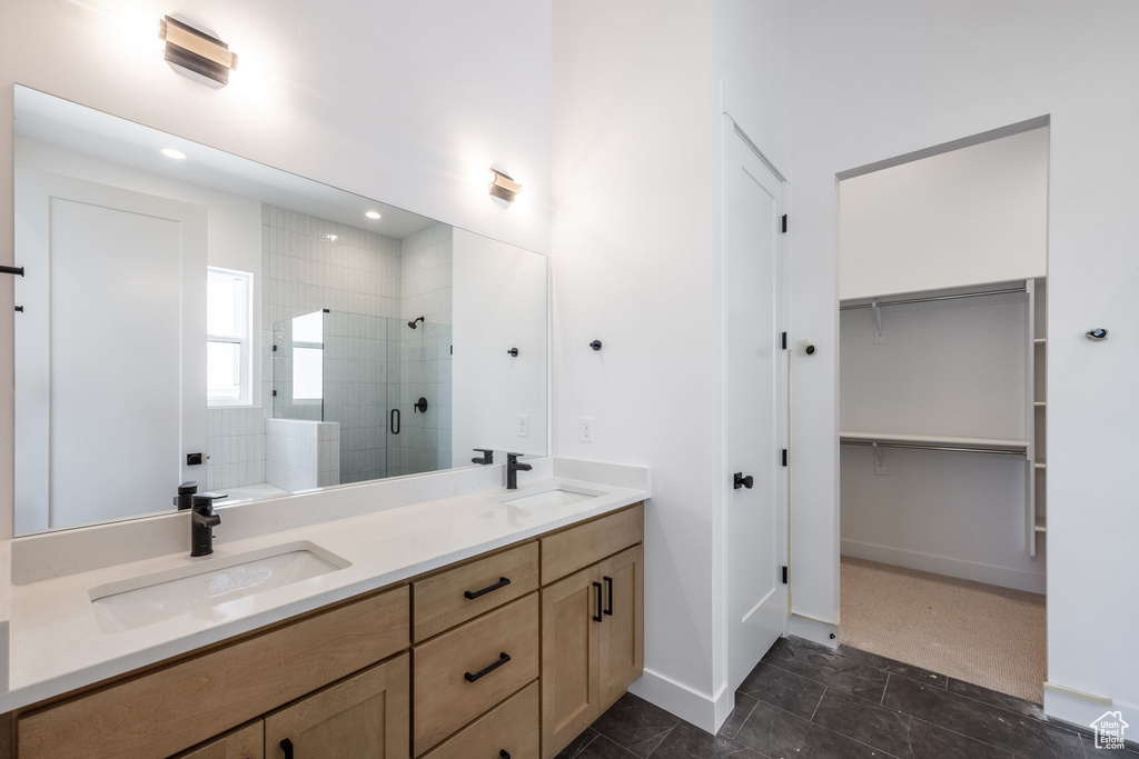 Bathroom featuring a shower stall, double vanity, a spacious closet, a bathtub, and recessed lighting