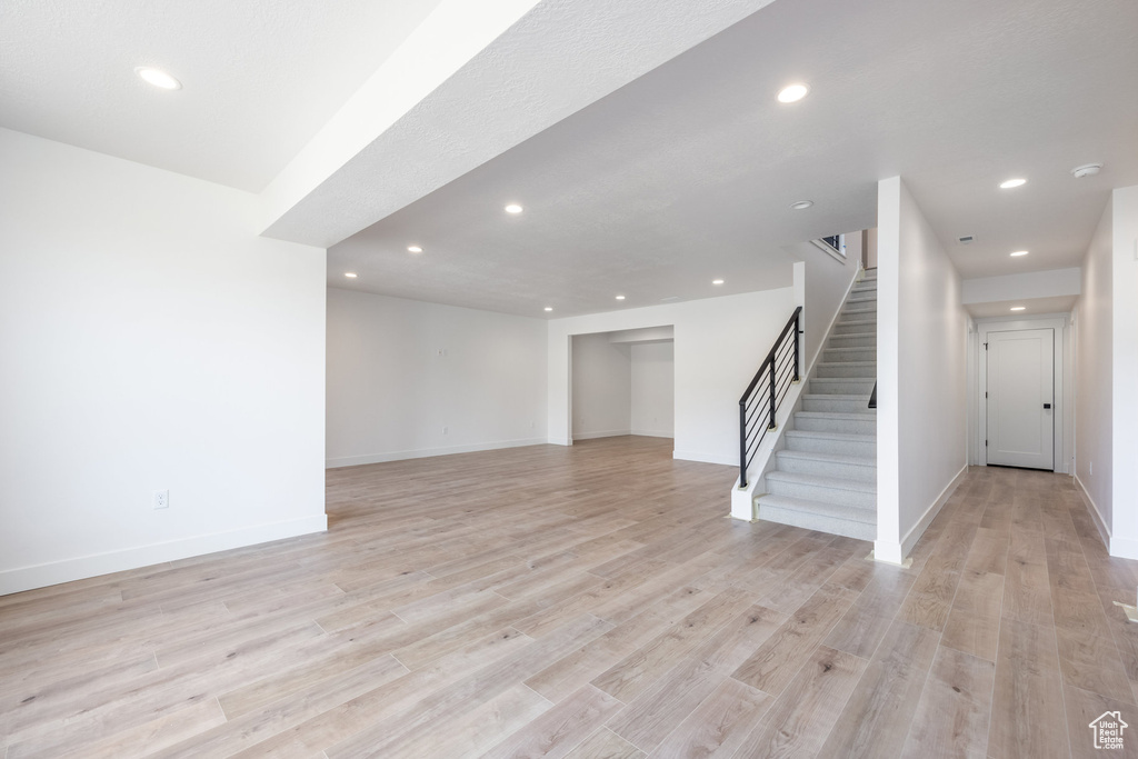 Unfurnished living room featuring recessed lighting, stairway, and light wood finished floors