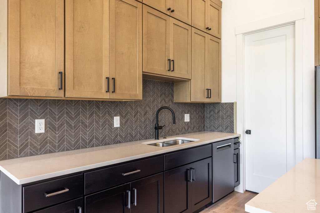Kitchen with light countertops, decorative backsplash, and light wood-style flooring