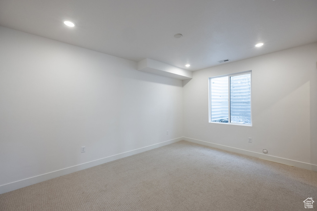 Empty room featuring light colored carpet and recessed lighting