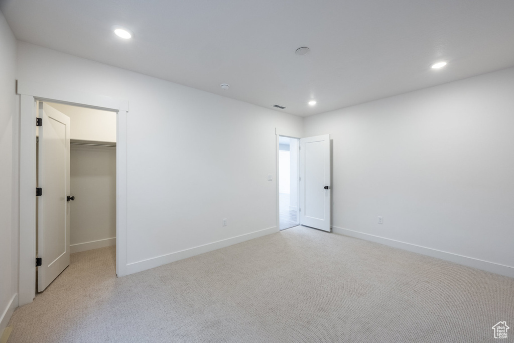 Spare room featuring light colored carpet and recessed lighting