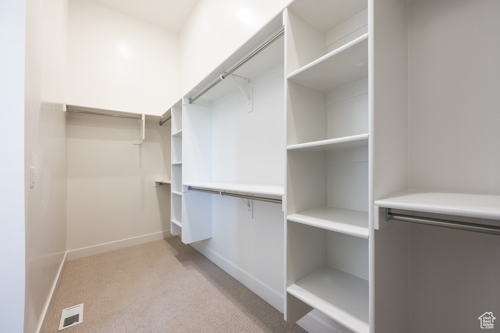 Walk in closet with light carpet