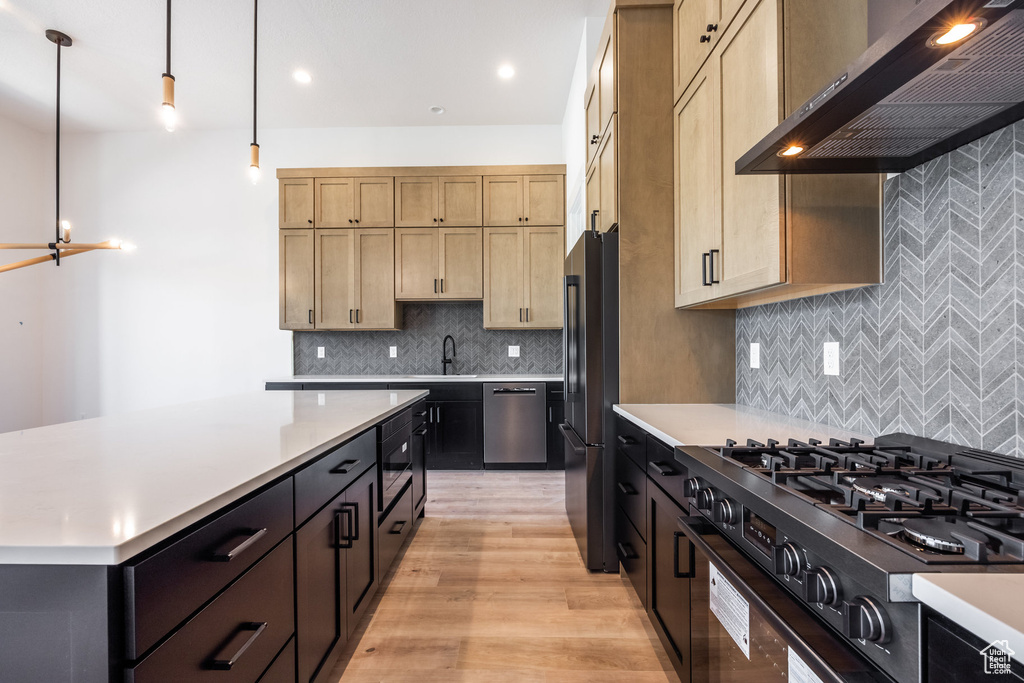 Kitchen with range hood, black appliances, light countertops, light wood finished floors, and light brown cabinetry