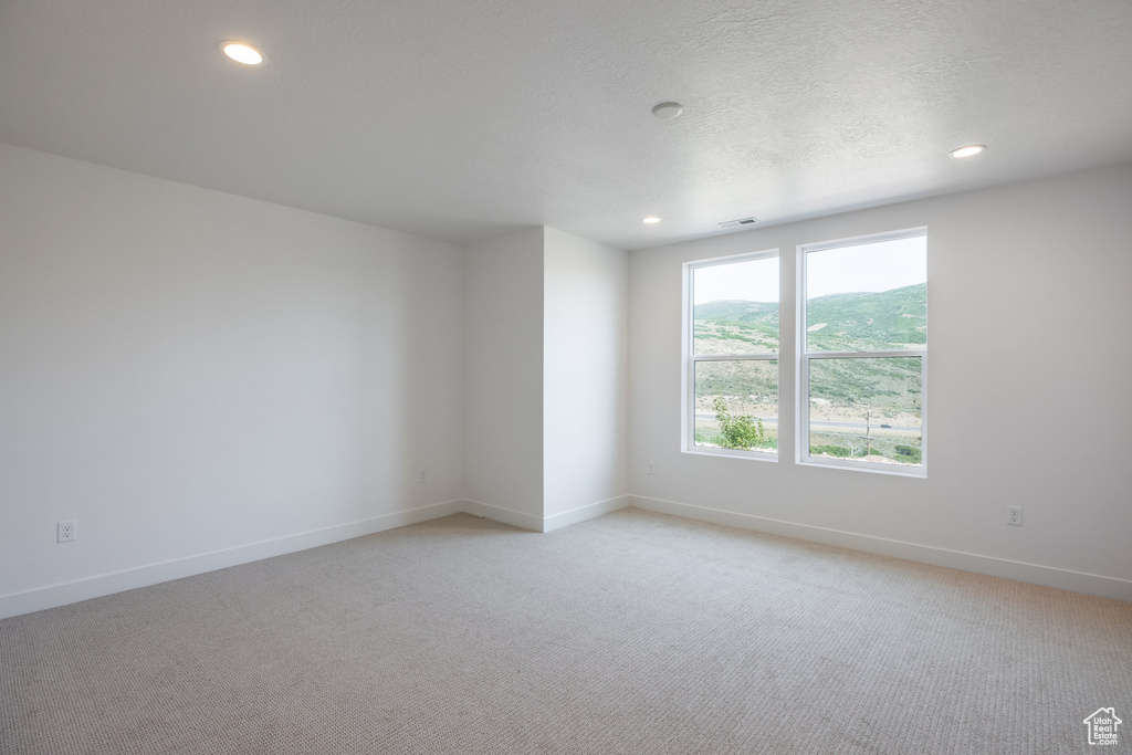 Spare room with light colored carpet and recessed lighting
