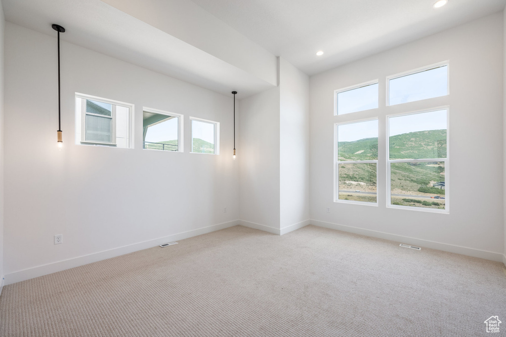 Unfurnished room with plenty of natural light, light colored carpet, and recessed lighting