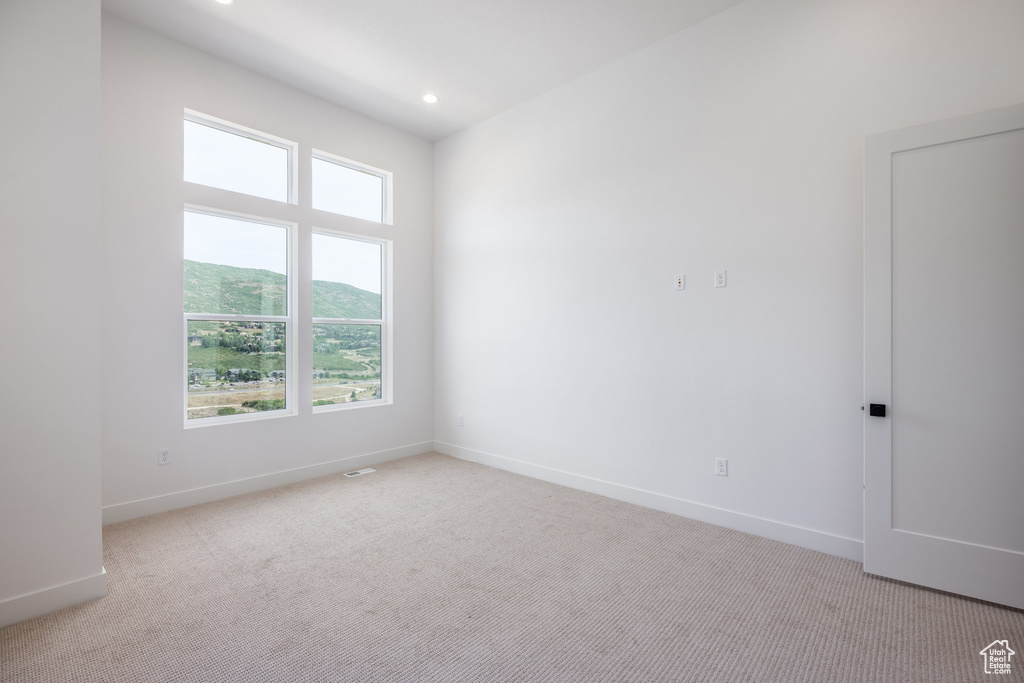 Unfurnished room featuring light carpet, recessed lighting, and a mountain view