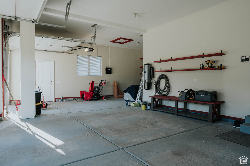 Garage with a garage door opener and a workshop area