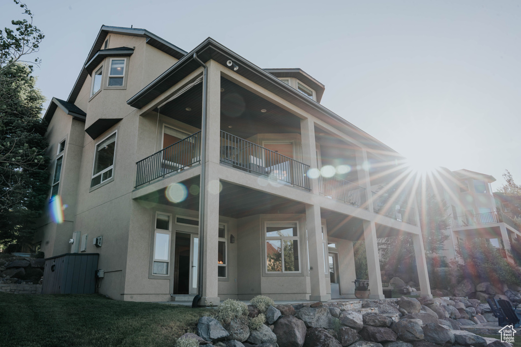 Back of house featuring stucco siding and a balcony