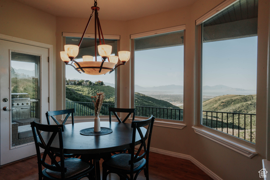 Dining space with a mountain view, dark wood-style floors, and a chandelier