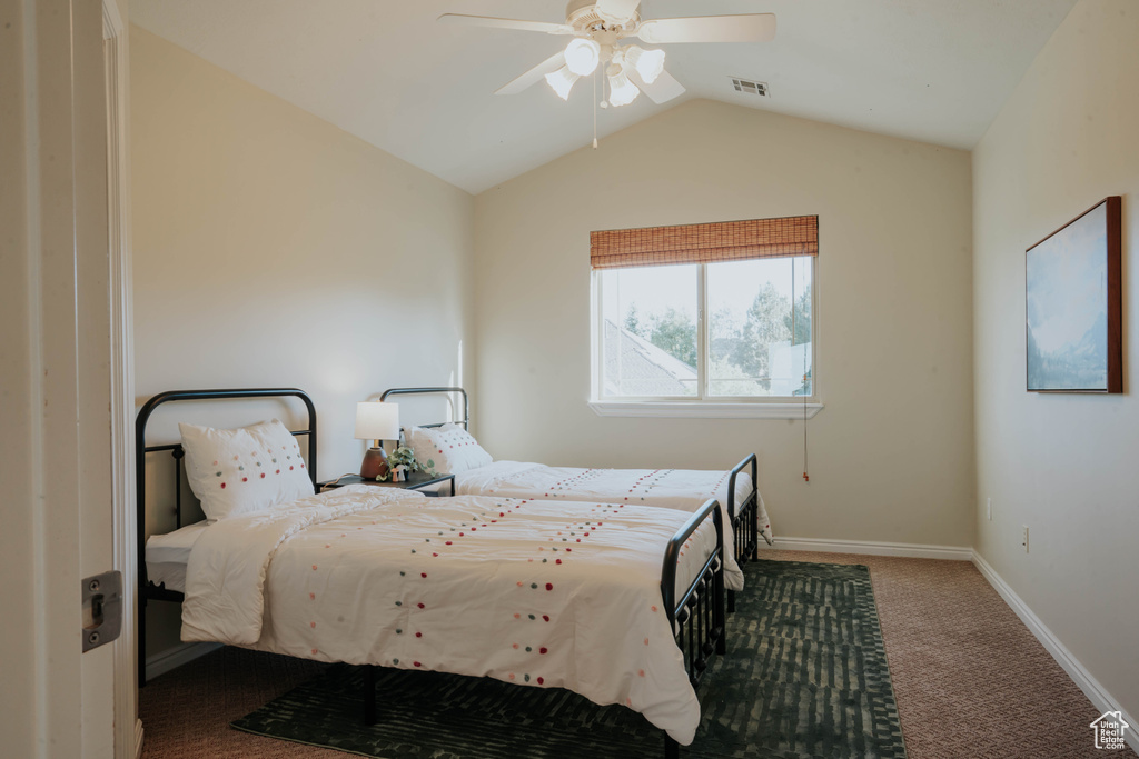 Carpeted bedroom with lofted ceiling and ceiling fan