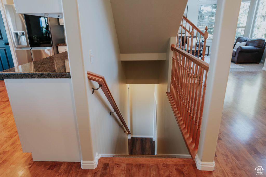 Stairway featuring wood finished floors and baseboards