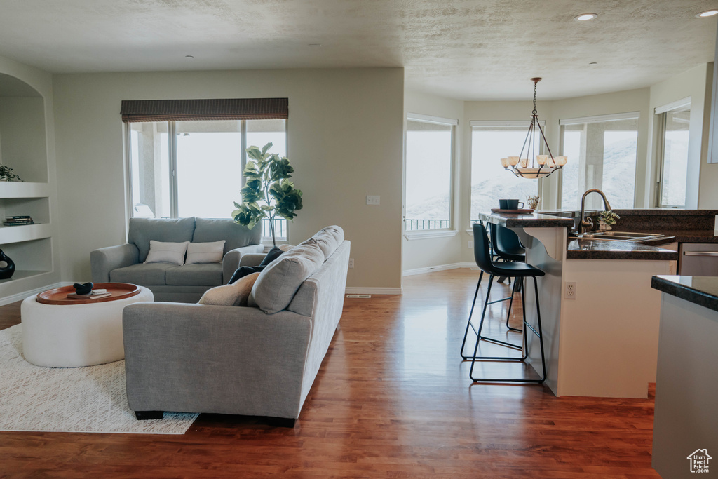 Living area featuring wood finished floors, recessed lighting, a chandelier, and built in shelves