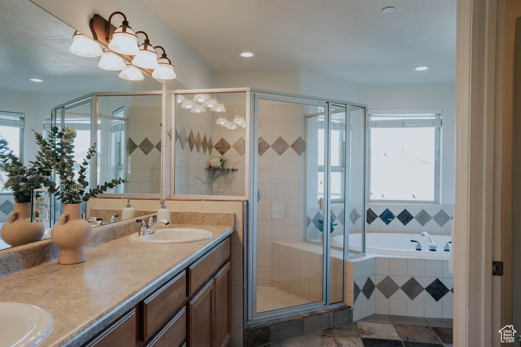Bathroom with double vanity, a stall shower, a bath, and recessed lighting