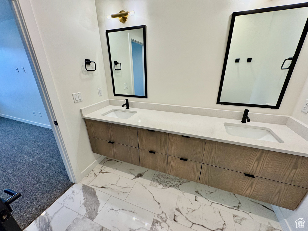 Bathroom with double vanity and marble look tile flooring