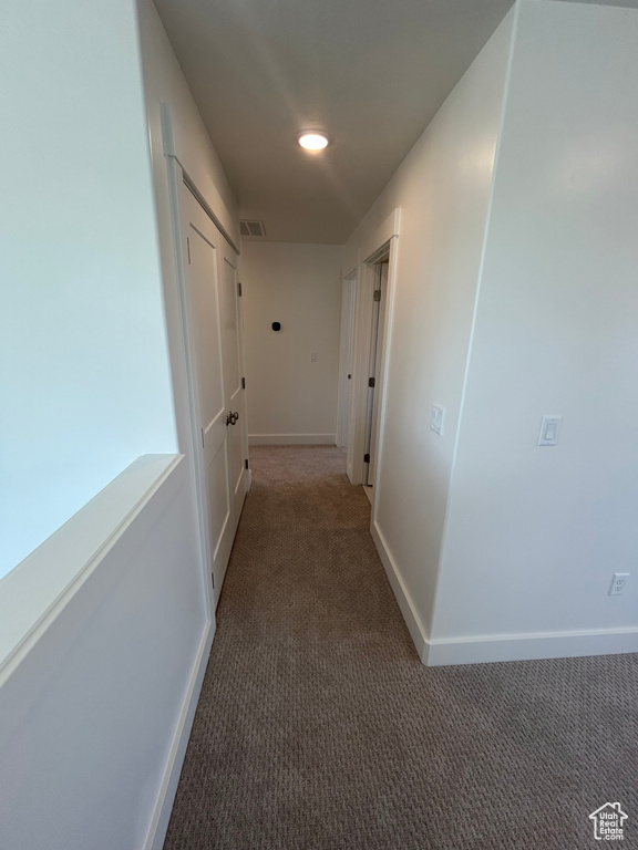 Corridor featuring carpet floors and baseboards