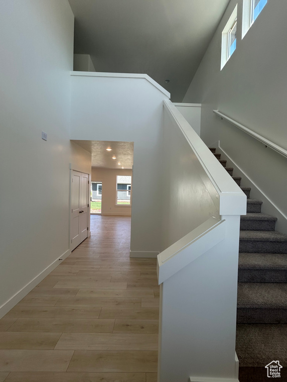 Stairway with a high ceiling and wood finished floors