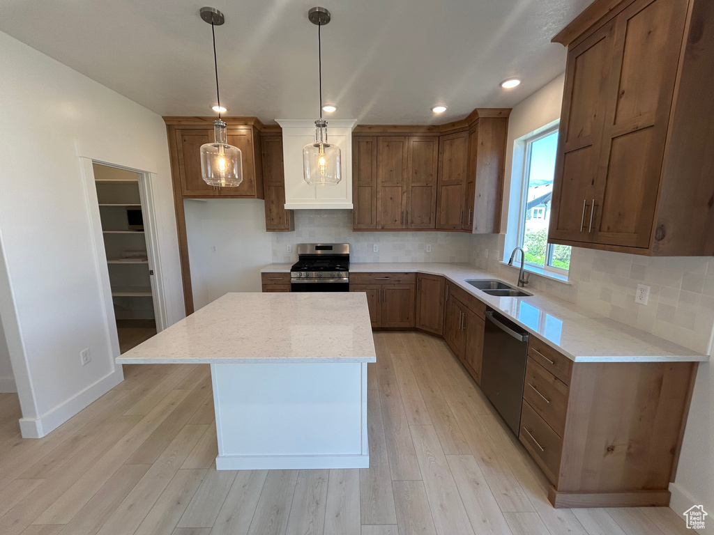 Kitchen with stainless steel appliances, a center island, decorative backsplash, light wood-style flooring, and recessed lighting