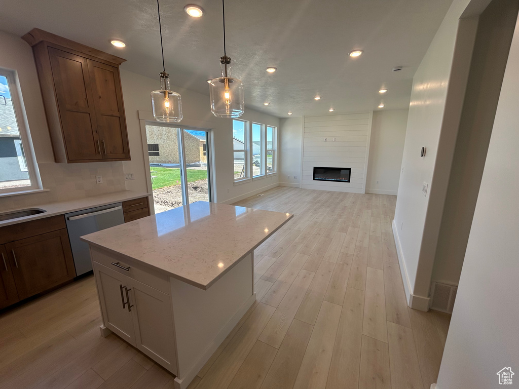 Kitchen featuring dishwasher, recessed lighting, light wood-style floors, pendant lighting, and open floor plan