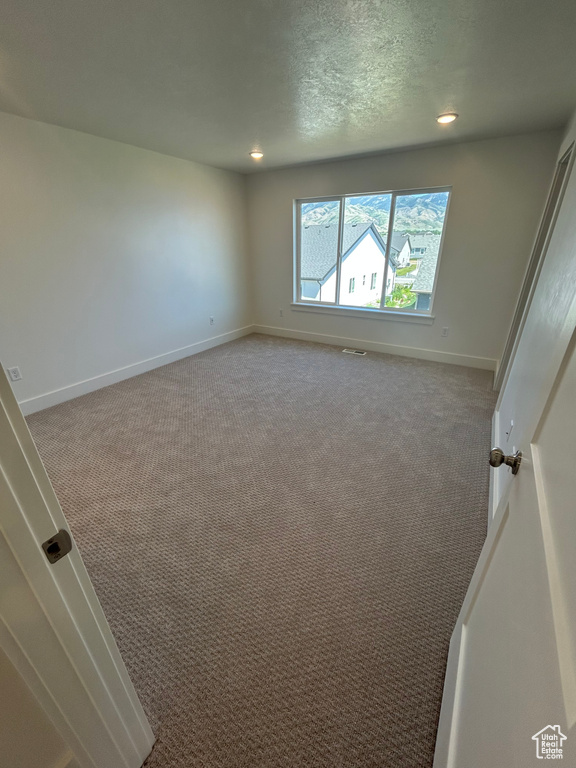 Carpeted empty room with recessed lighting