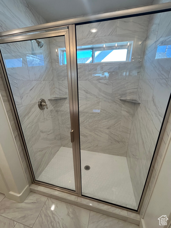 Bathroom featuring a stall shower and marble look tile flooring
