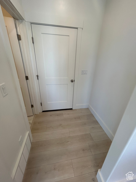 Hallway featuring light wood finished floors and baseboards