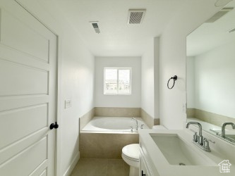 Full bath with a garden tub, vanity, and tile patterned flooring