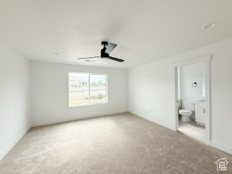 Unfurnished bedroom featuring carpet flooring, connected bathroom, and a ceiling fan